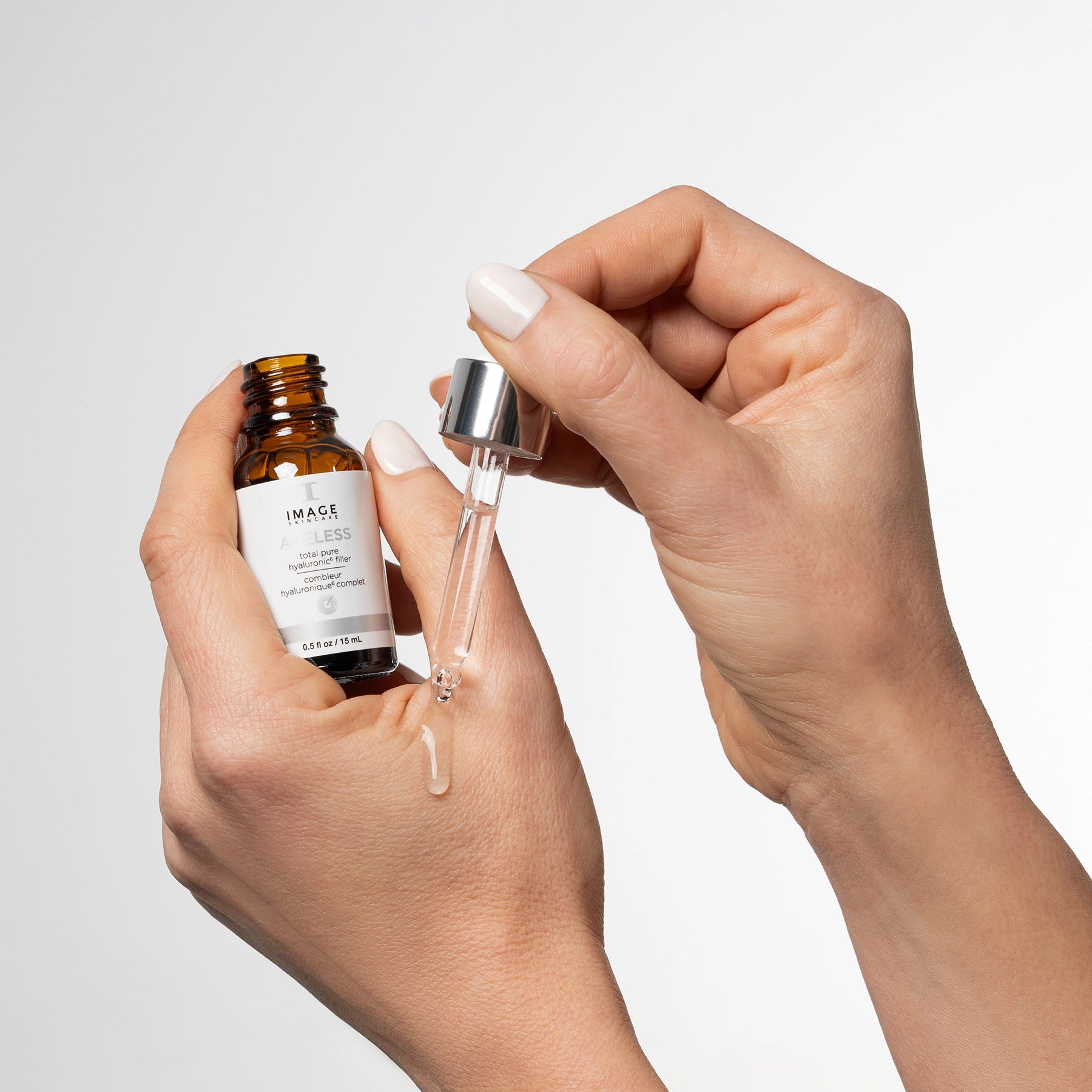 model hands applying hyaluronic filler to hand with droplet