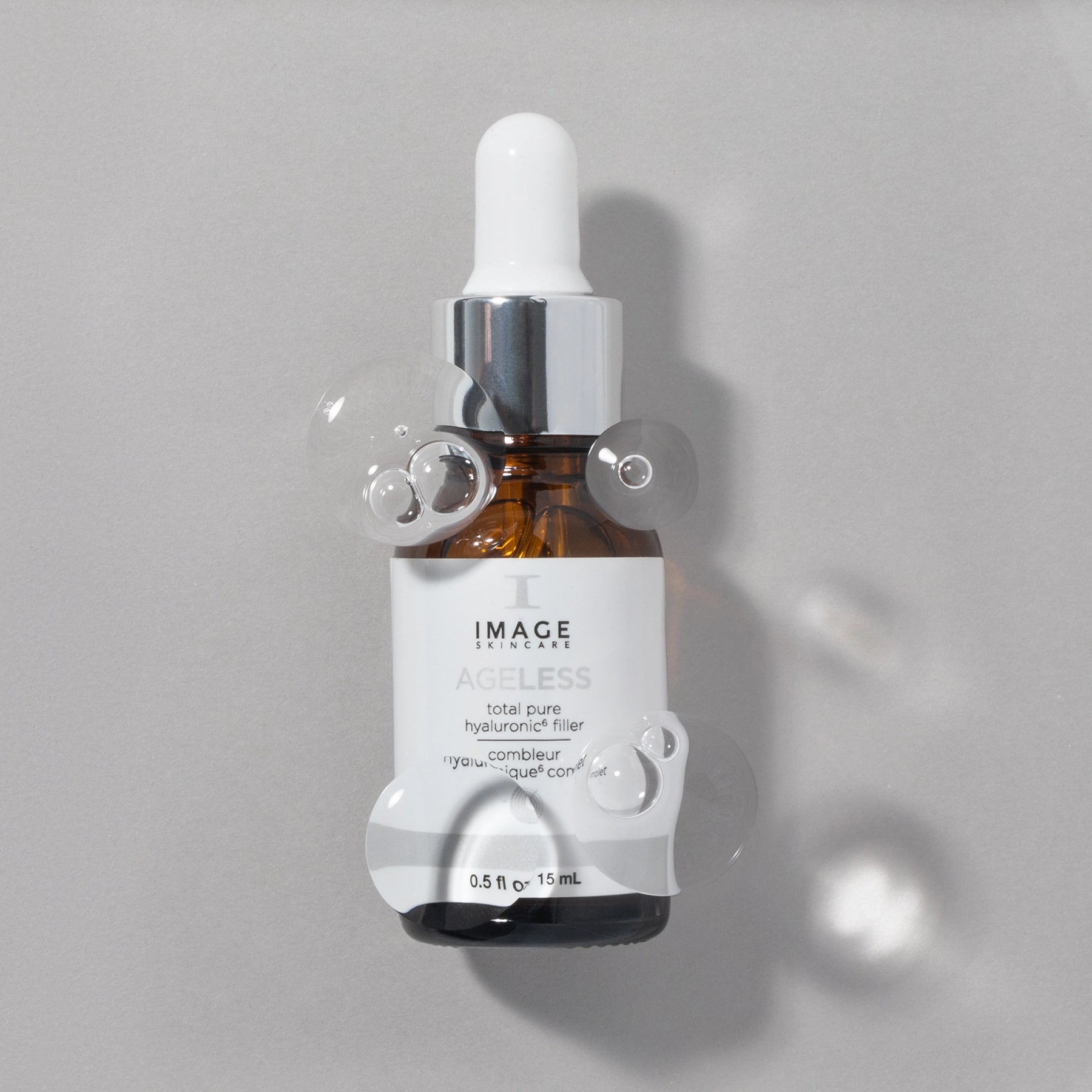Ageless pure hyaluronic filler bottle on gray background with bubbles