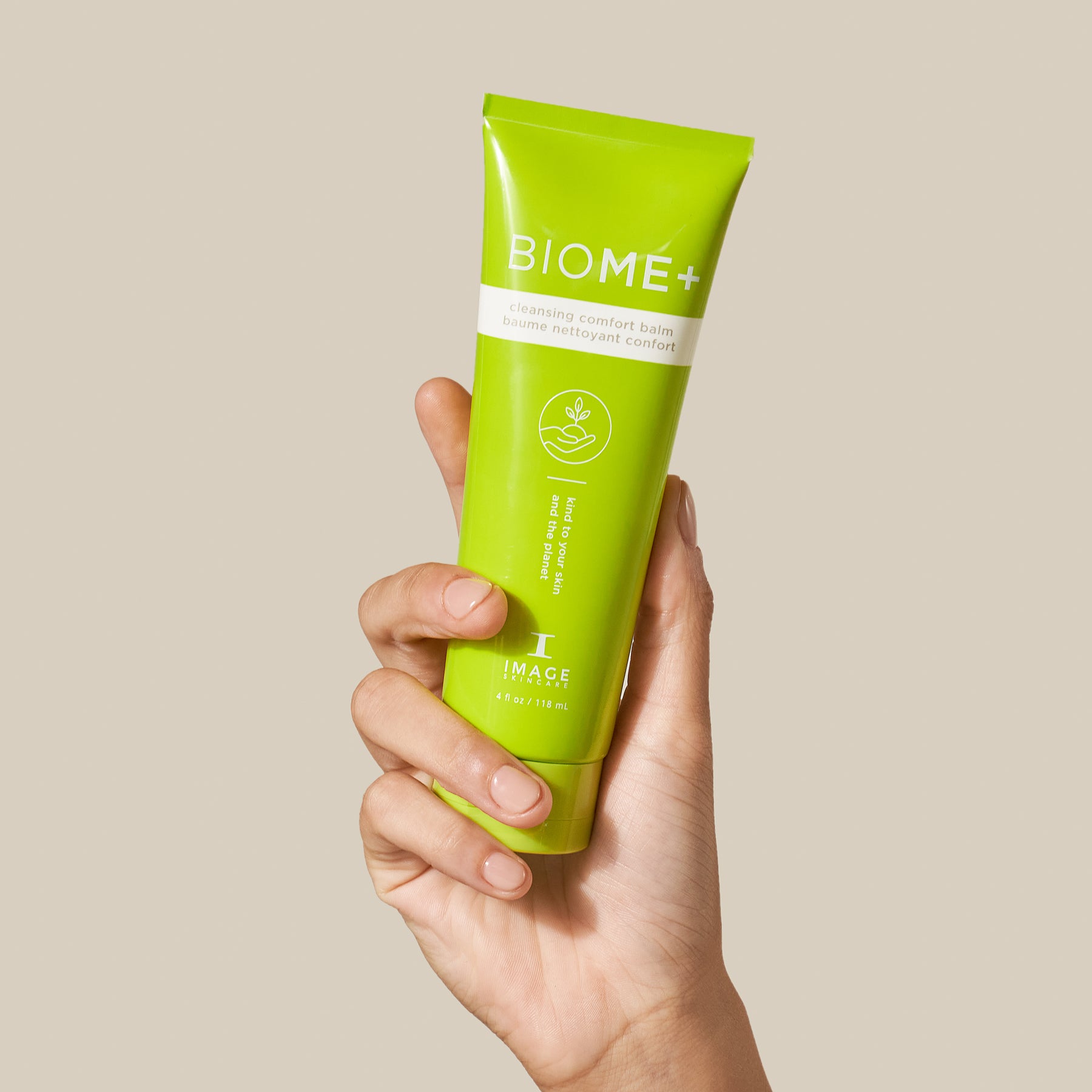 model hand holding tube of cleansing comfort balm