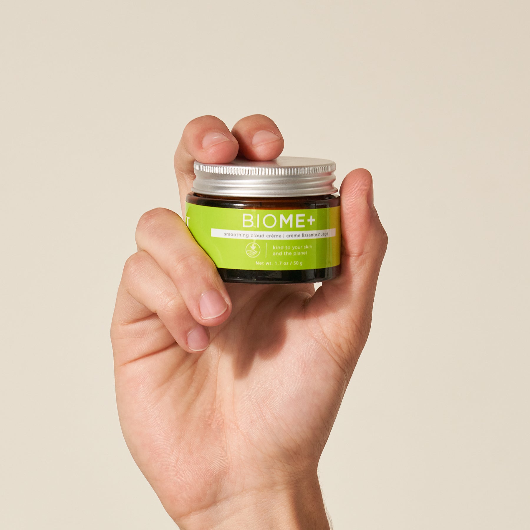 model hand holding smoothing cloud creme container