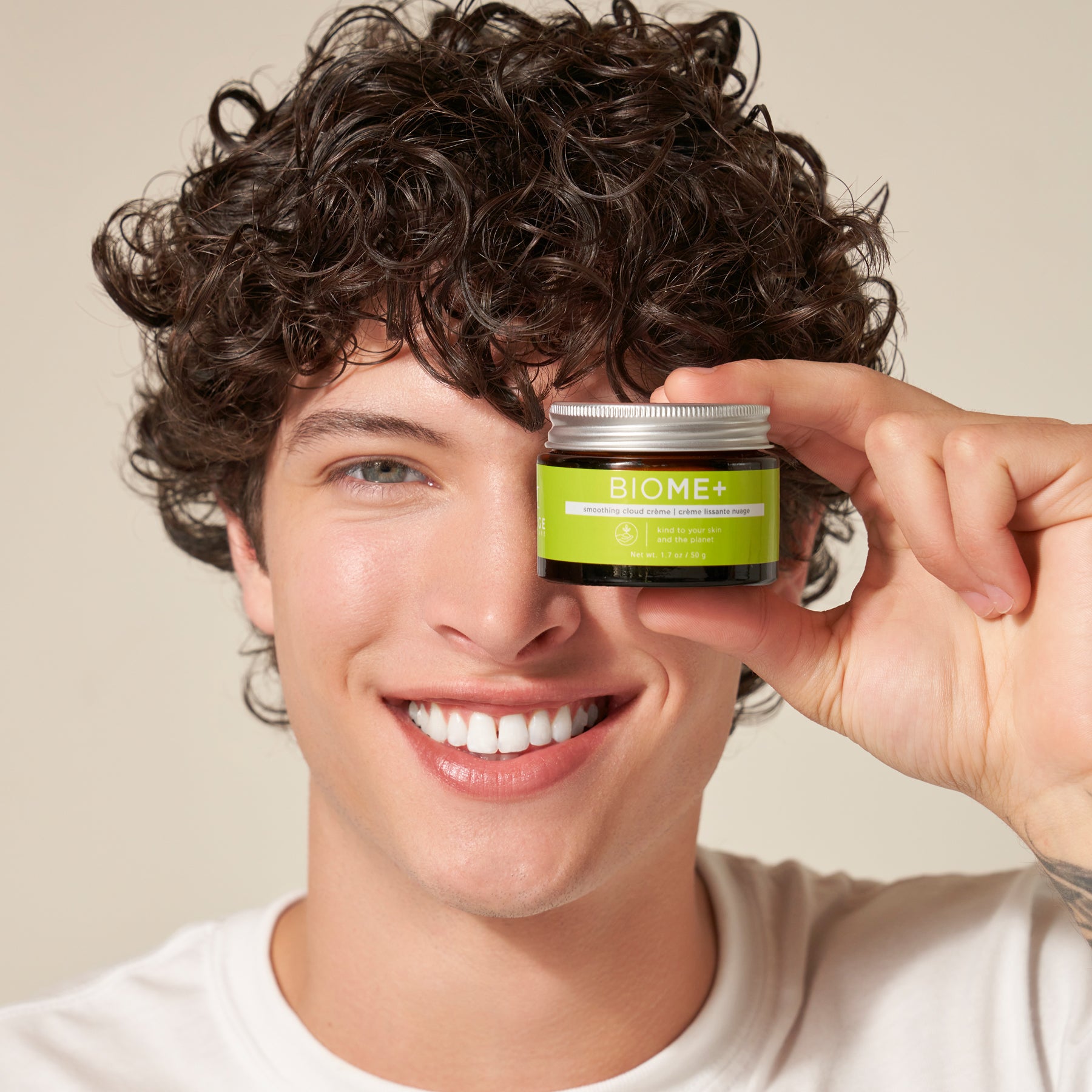 male model holding smoothing cloud creme container up to his face