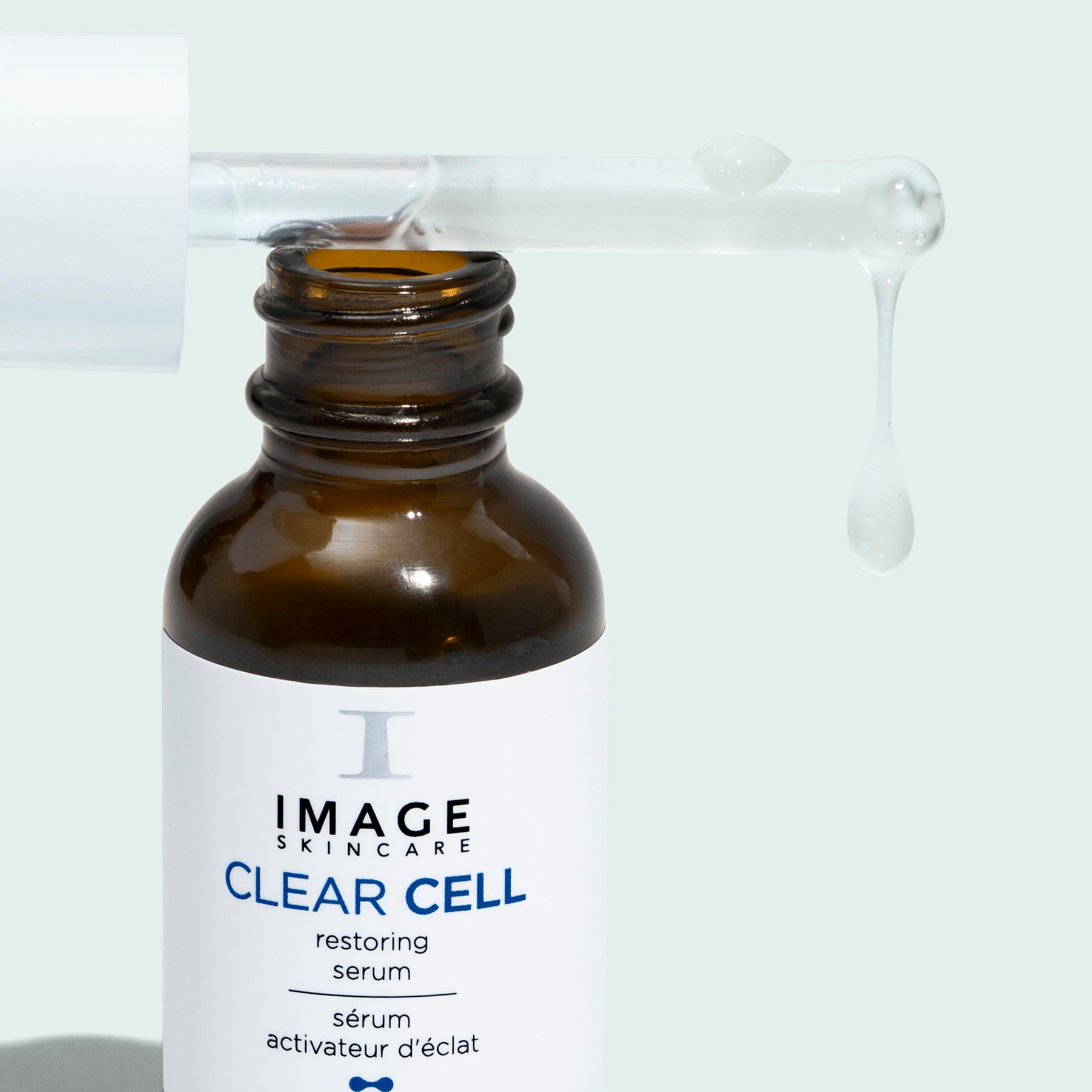 clear cell resotring serum open bottle with applicator dripping serum