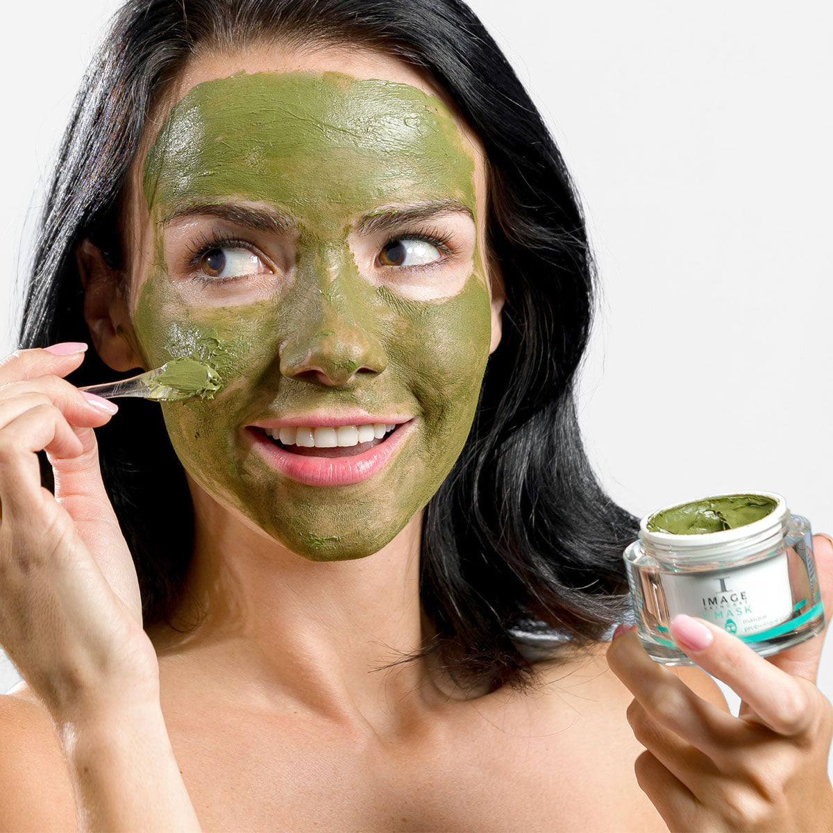model applying probiotic mask to face