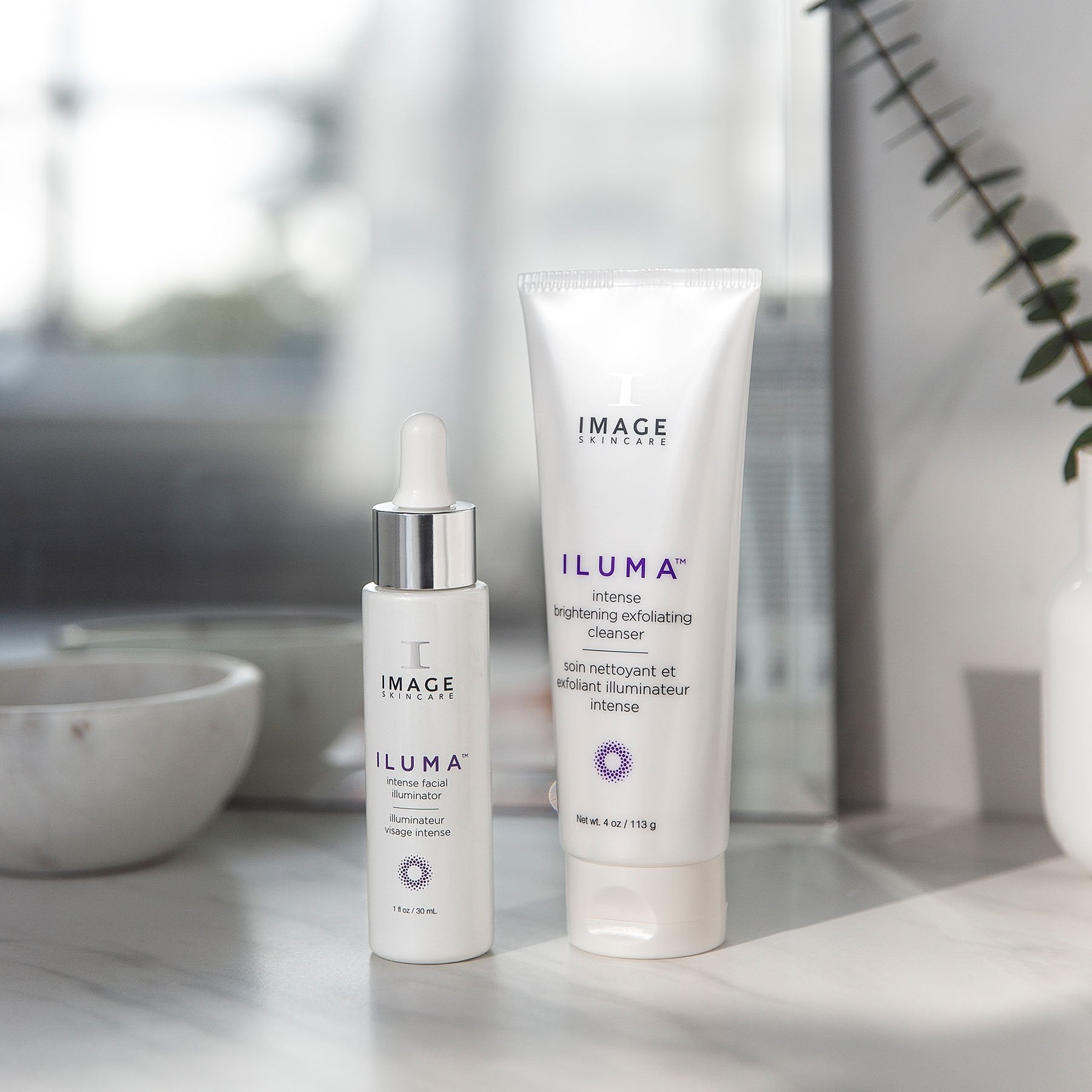 iluma intense facial illuminator bottle and exfoliating cleanser tube on bathroom counter