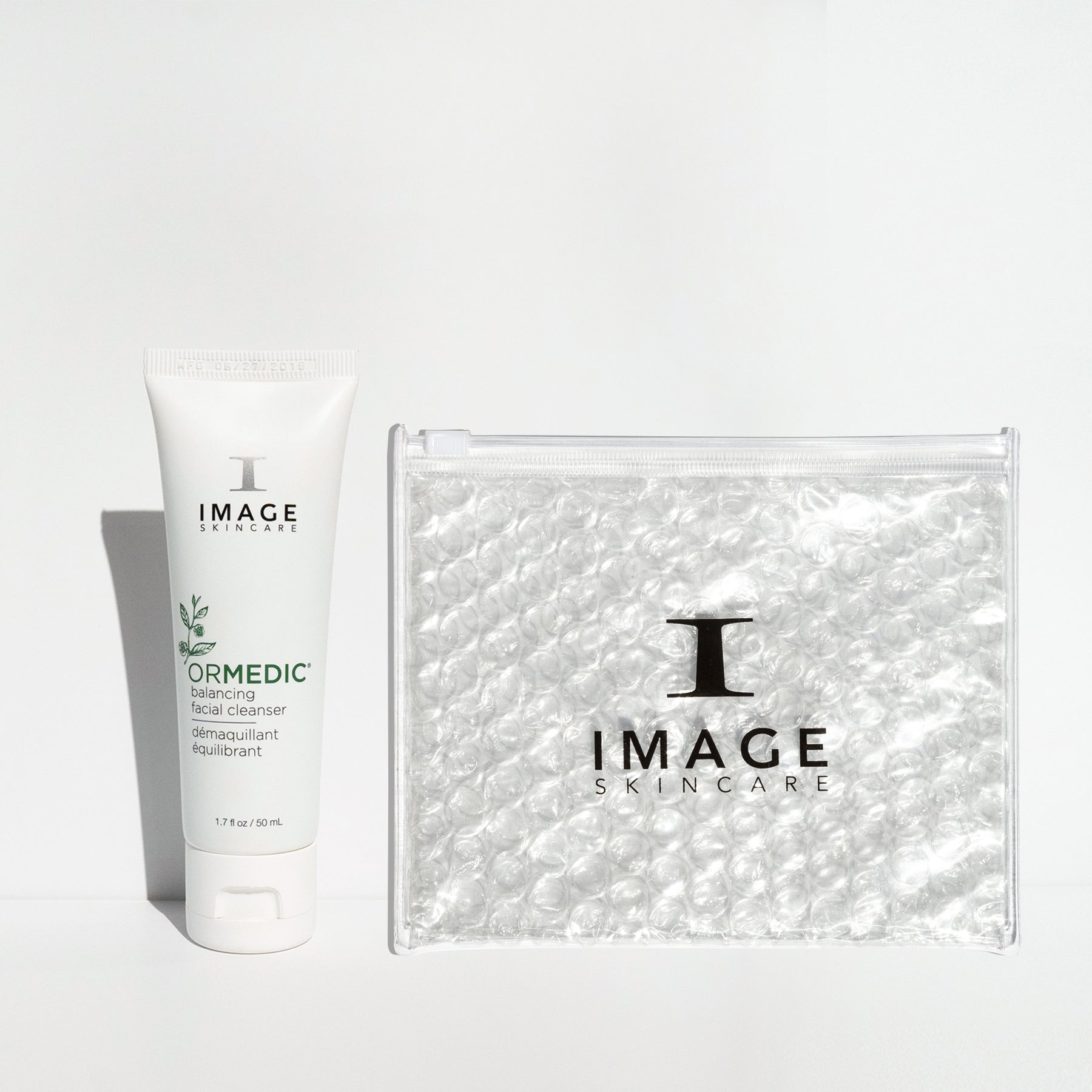 travel size cleanser positioned next to bubble bag on white background