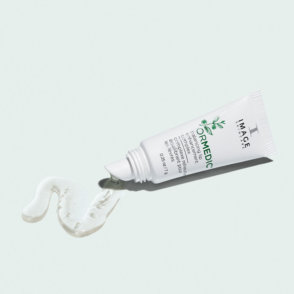 open tube of ormedic lip complex with product pouring out on light background