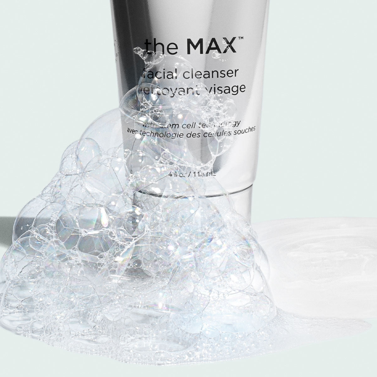 Close up of MAX cleanser tube with bubbles on light background