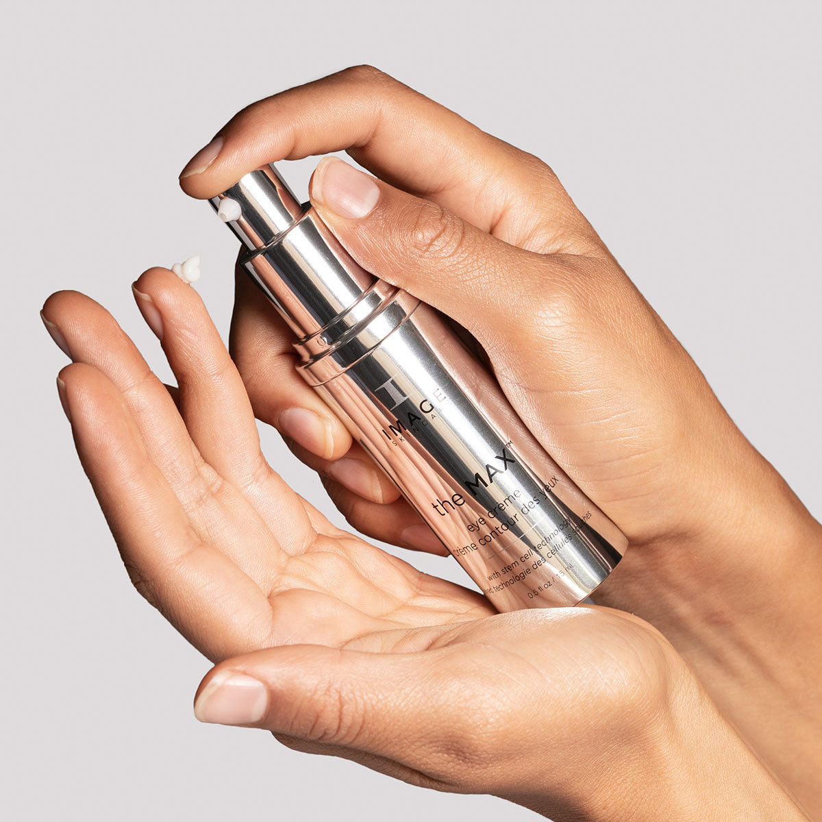 model hands dispensing eye creme onto finger