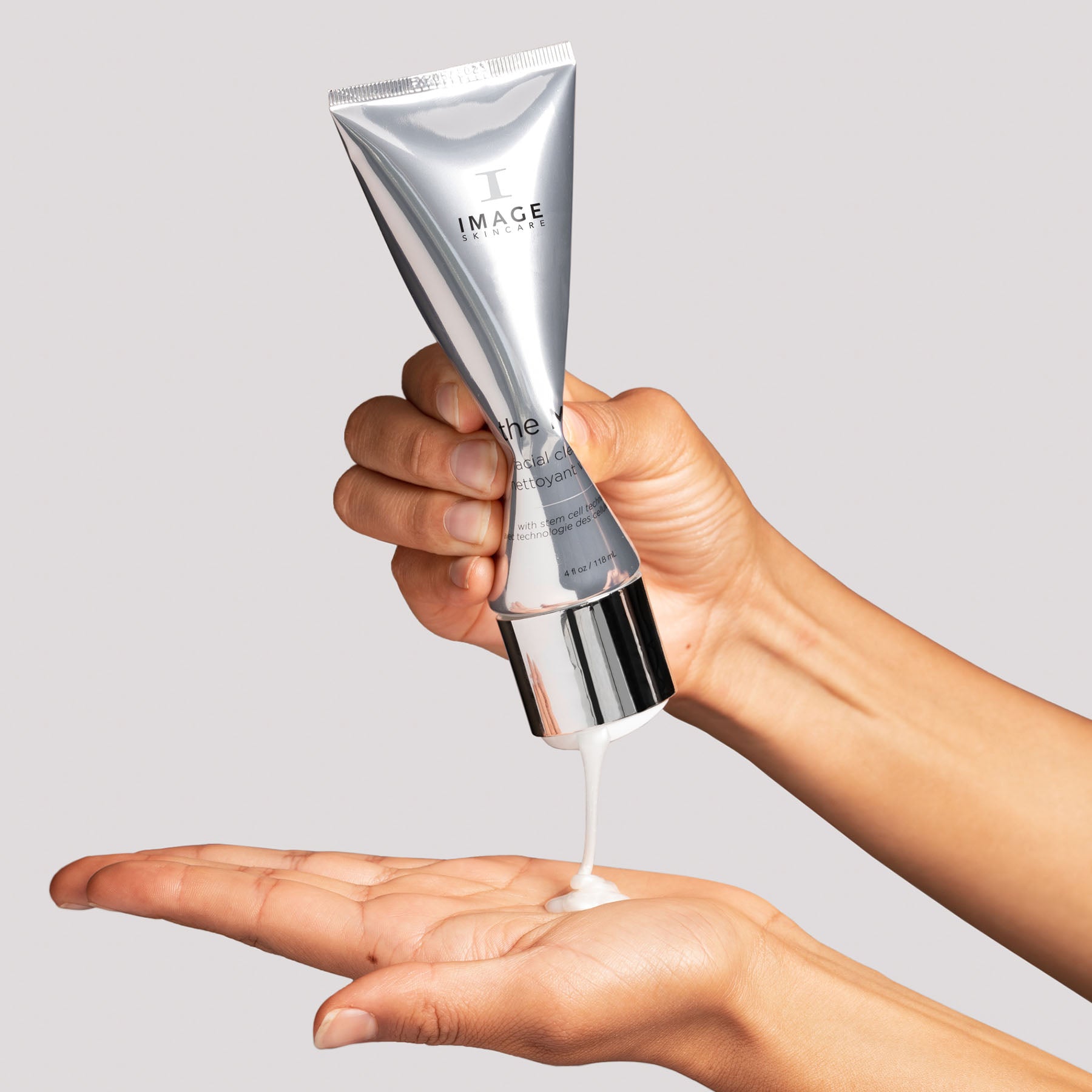 model hands squeezing MAX cleanser tube and dispensing product onto palm