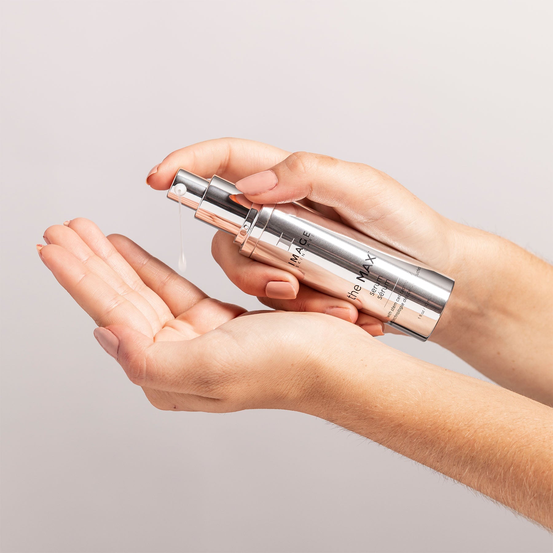 model hands dispensing serum onto palms