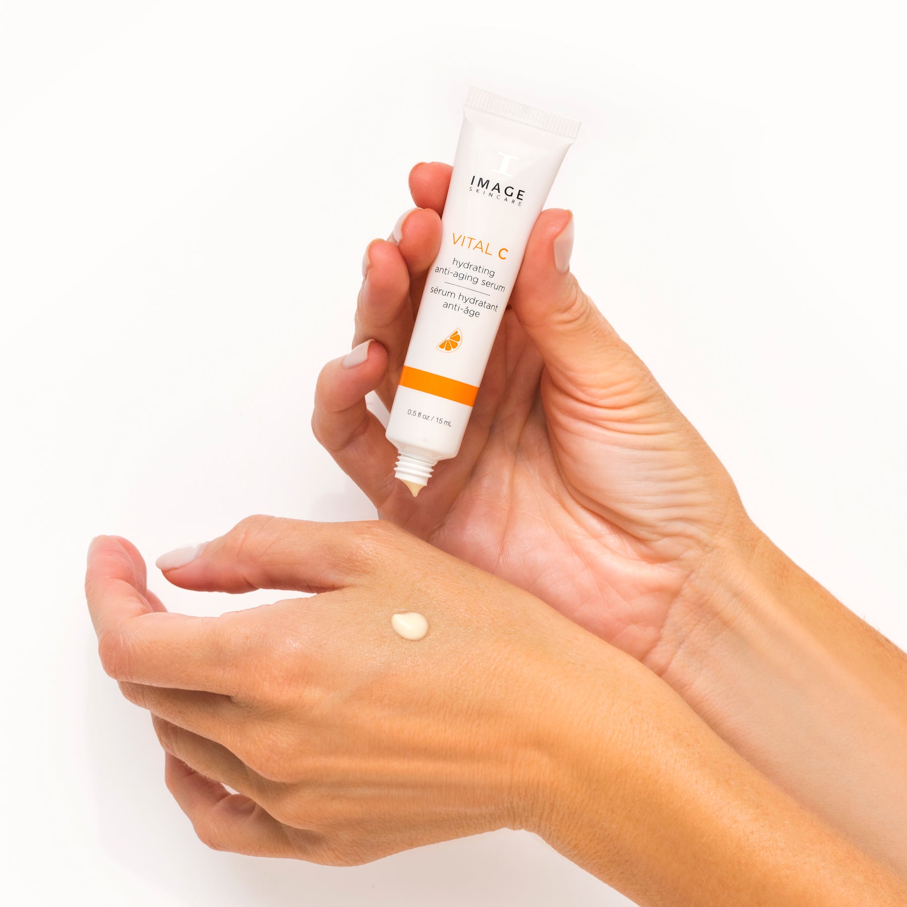 model hands applying serum swatch on hand