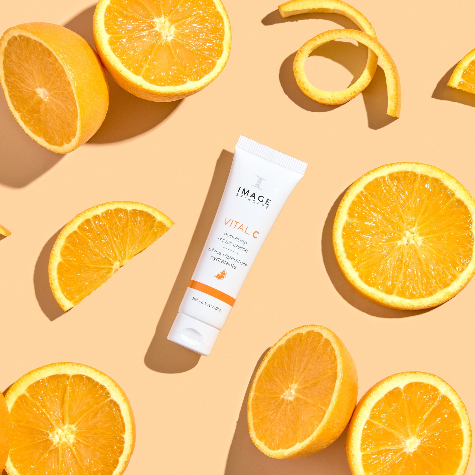travel size repair creme on orange background with orange slices