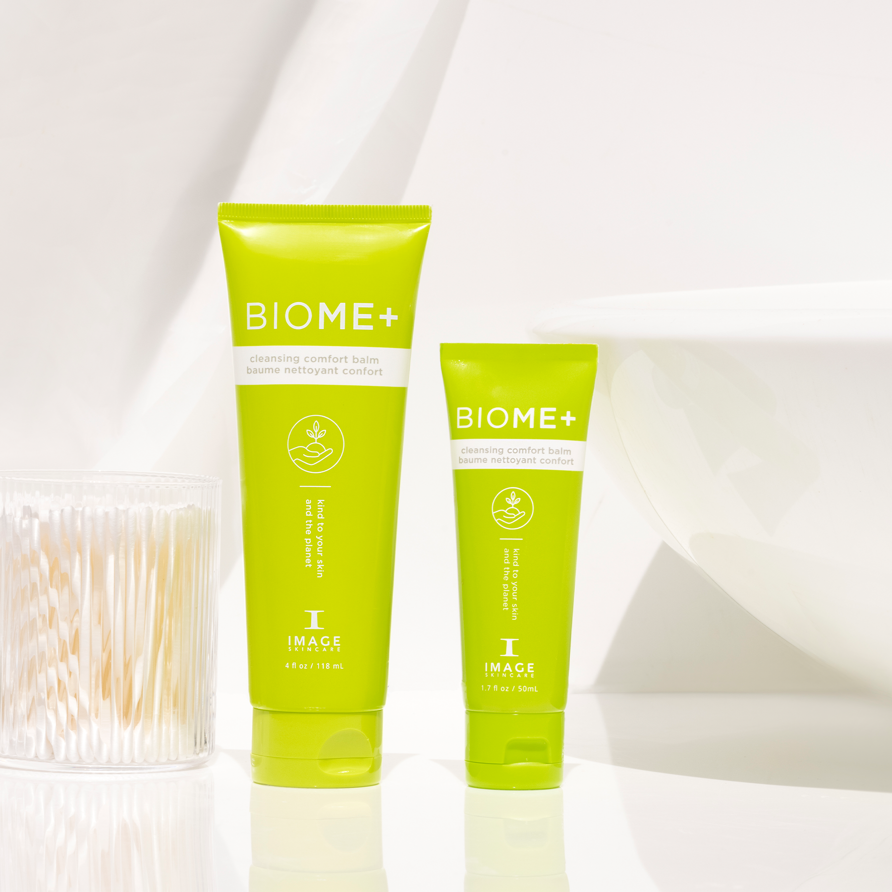 BIOME+ comfort cleansing balm retail and travel size bottles on white bathroom counter